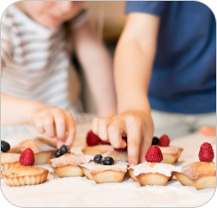 Enfant mesurant des ingrédients pour des muffins, décorant des muffins cuits.