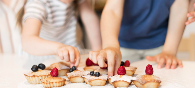 Enfant mesurant des ingrédients pour des muffins, décorant des muffins cuits.